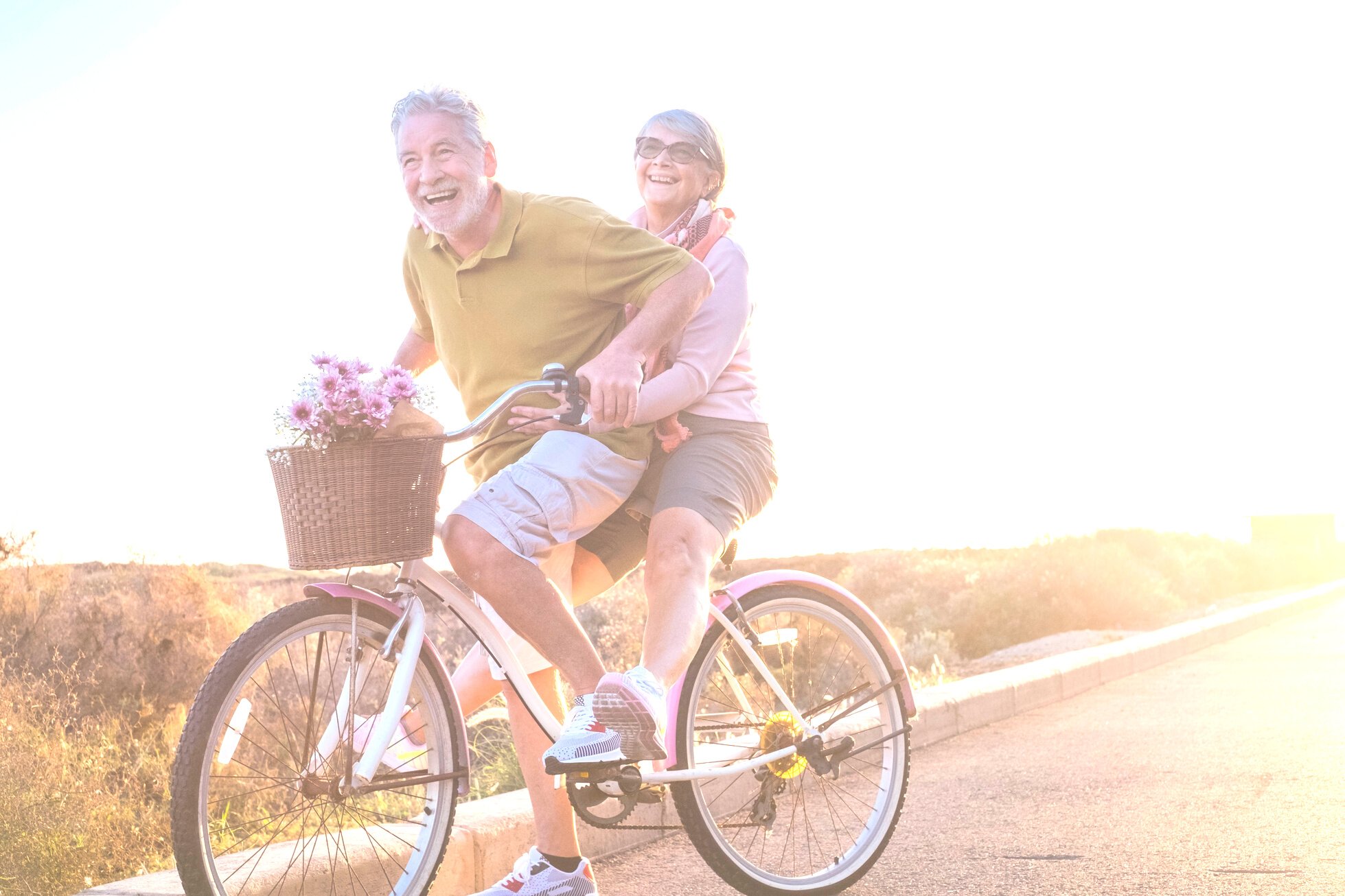 Elderly Couple Riding a Bicycle Together Outdoors